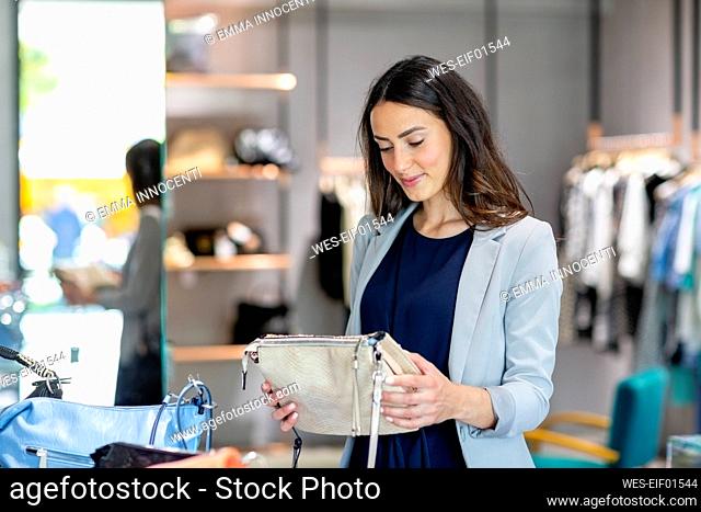 Young woman holding purse while shopping in store