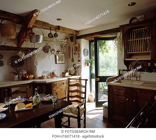 Rush-seated ladderback chair and wooden table in fitted cottage kitchen
