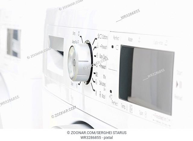 closeup of new white laundry or washing machine, selective focus on control elements