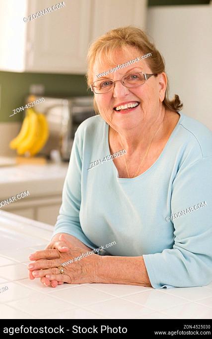 Portrait of a Beautiful Smiling Senior Adult Woman in Kitchen