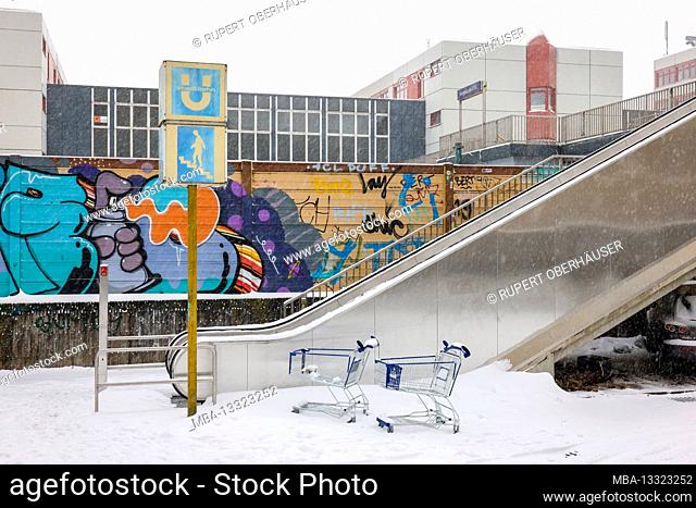 Essen, North Rhine-Westphalia, Germany - onset of winter in the Ruhr area, shopping trolleys stand in the snow on an escalator to the subway station
