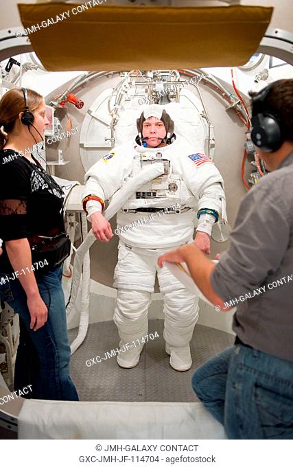 Astronaut Robert Behnken, STS-130 mission specialist, participates in an Extravehicular Mobility Unit (EMU) spacesuit fit check in the Space Station Airlock...