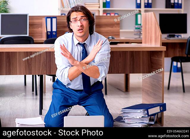 The young male employee and too many work in the office