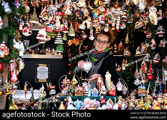 22 November 2021, Berlin: Irene Osenbrügge offers tree decorations and pendants at her stand at the Gendarmenmarkt Christmas market