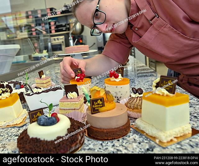 08 December 2023, Brandenburg, Fürstenwalde: Michelle Thiede, pastry chef, makes small handmade cakes for the opening of the Le Gateau rose cake factory