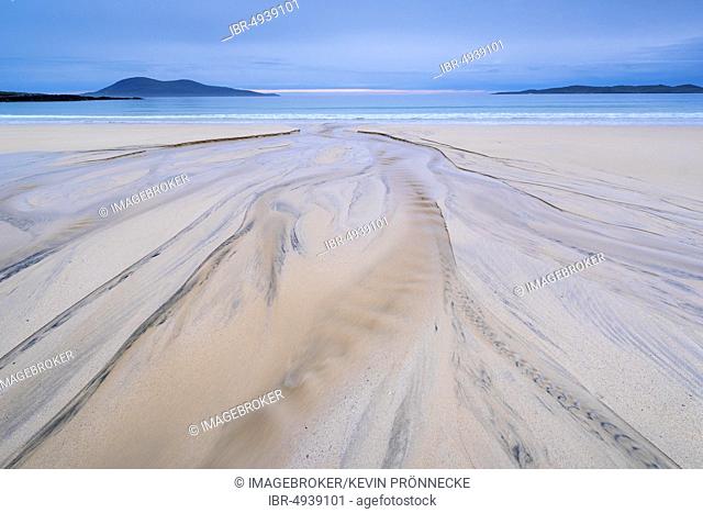Stream flows into the sea at low tide over a sandy beach, behind Ceapabhal Mountain, Isle of Harris, Scotland, United Kingdom, Europe