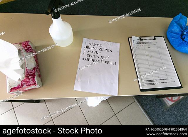 20 May 2020, Schleswig-Holstein, Kiel: A slip of paper with hygiene regulations lies next to paper towels, disinfectants and a list of names on a table at the...