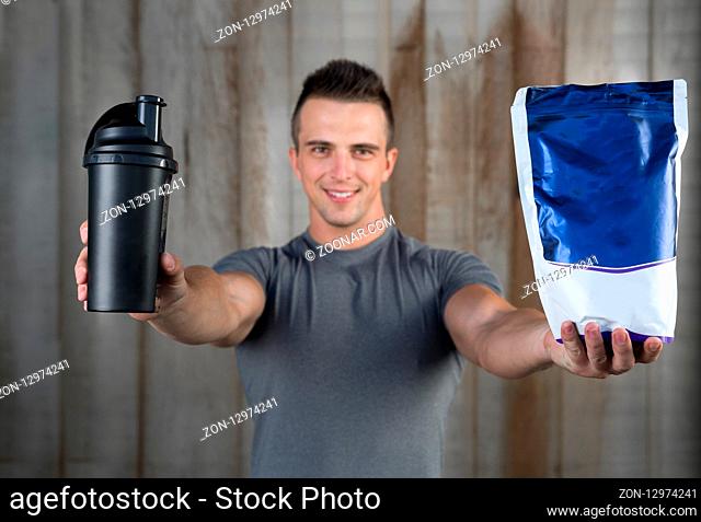 Muscular handsome sportman or bodyuilder with pills and suplements for copy space. For product display montage. Business presentation