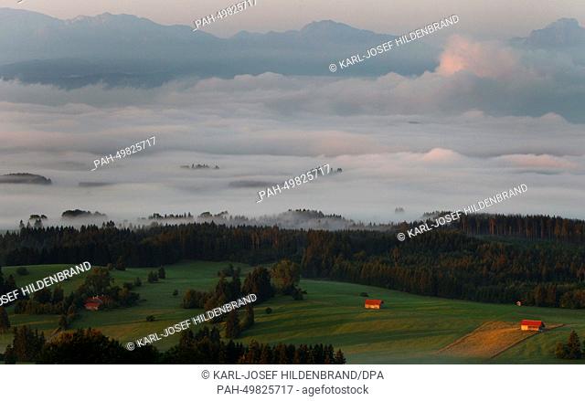 The alpine upland is covered with early morning fog during sunrise near Bernbeuren, Germany, 26 June 2014. Photo: Karl-Josef Hildenbrand/dpa | usage worldwide