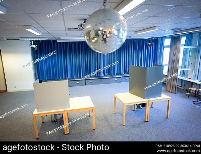 26 September 2021, Berlin: Voters sit under a disco ball in the voting booth for the federal election and the election of the House of Representatives