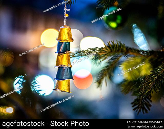 09 December 2022, Hessen, Frankfurt/Main: Empty aluminum coffee capsules, strung on a string, hang as Christmas tree decorations on a Christmas tree in the...