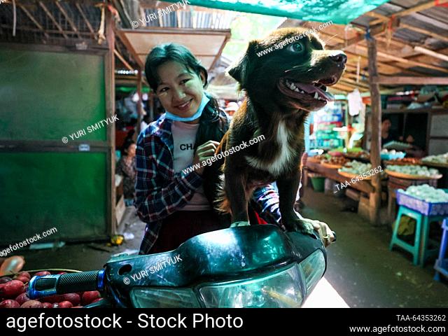 MYANMAR, YANGON - OCTOBER 28, 2023: A woman with a dog at Nyaung U Market. Yuri Smityuk/TASS