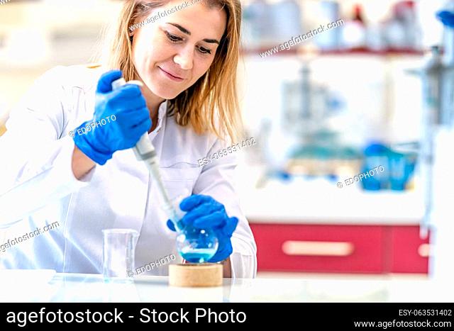 young female scientist conducts chemical experiments in a research laboratory