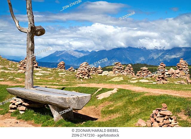 Sitzbank mit Steinmännchen in den italienischen Alpen