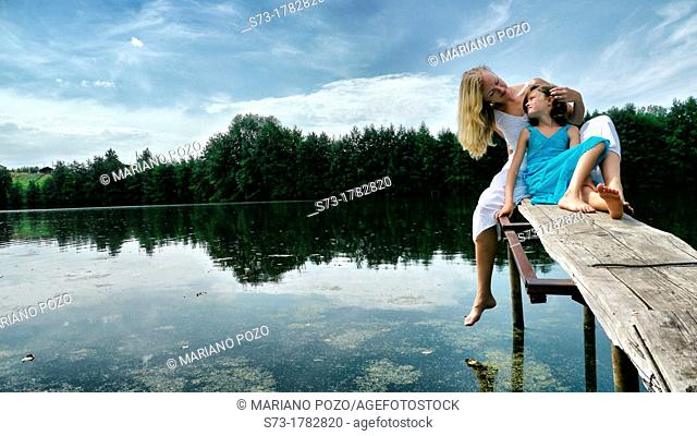 Woman and daughter on the pier in Lake Avral, Kirillovka, Samara Region, Russian Federation