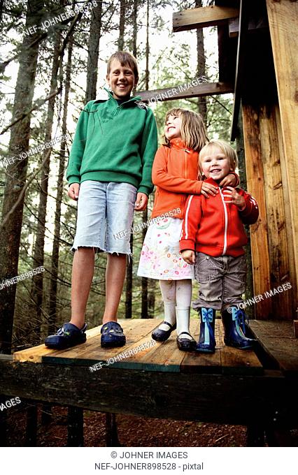 Three children playing in the forest, Sweden