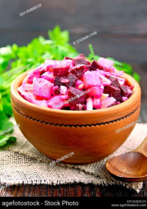 Vinaigrette salad with pickled or sauerkraut, potatoes, beetroot and onions, seasoned with vegetable oil in a bowl on burlap
