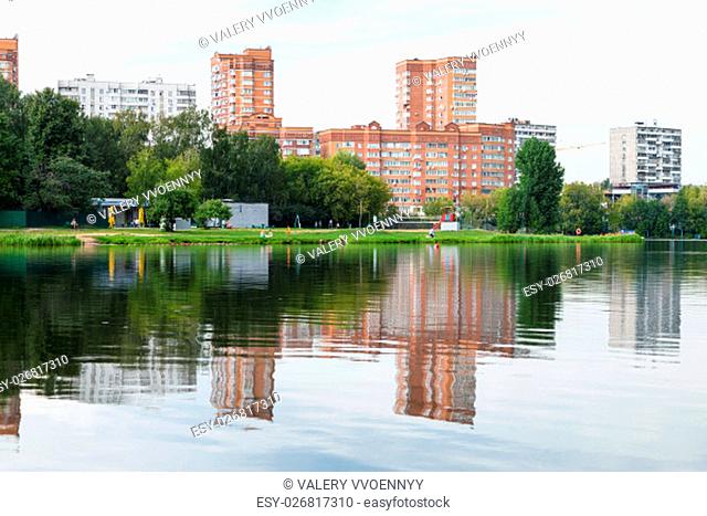 green recreation area on shore of the city pond. Big Garden (Academic) Pond, Moscow