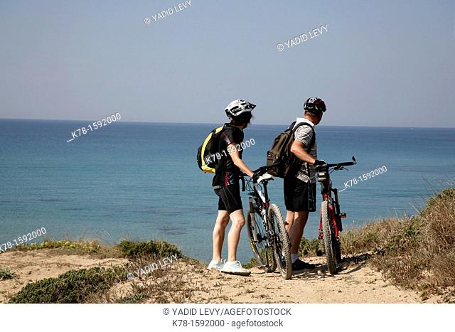 Couple ona mountain bikes by San Giovanni di Sinis beach on the Sinis peninsula, Sardinia, Italy