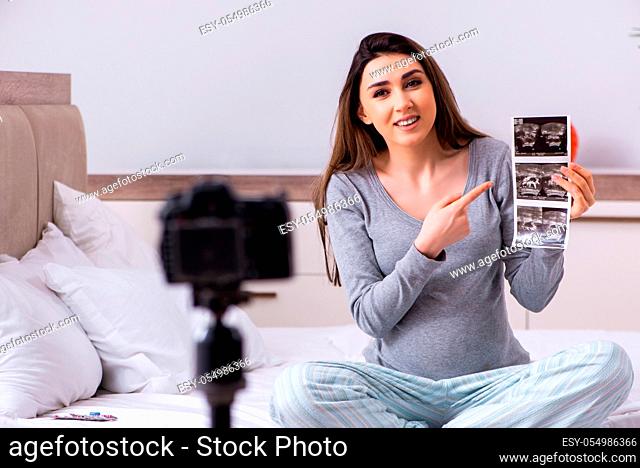 Pregnant woman recording video for her blog