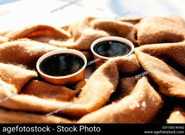 Two cups of coffee on a scarf in the snowy forest. High quality photo