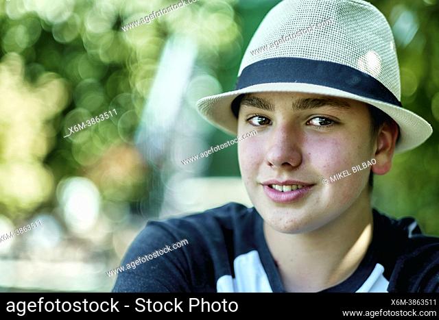 Portrait of young caucasian boy wearing a hat outdoor in a garden. Lifestyle concept