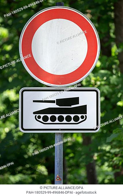 29 May 2018, Germany, Augustdorf: A road sign ""no entry"" and a sign depicting a tank standing on a road near the military barrack of the German army...