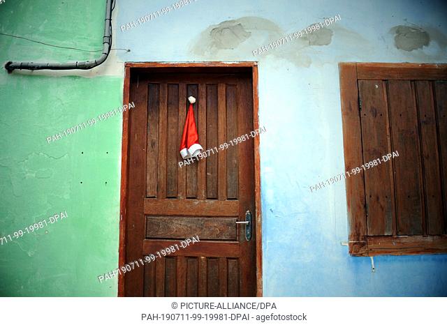 25 January 2018, Brazil, Paraty: A Santa hat hangs from a door in Paraty. Photo: Britta Pedersen/dpa-Zentralbild/ZB. - Paraty/Brazil/Brazil