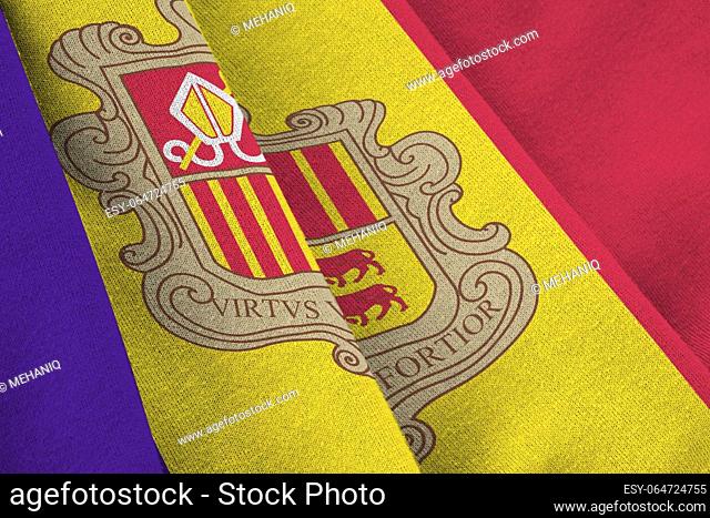 Andorra flag with big folds waving close up under the studio light indoors. The official symbols and colors in fabric banner