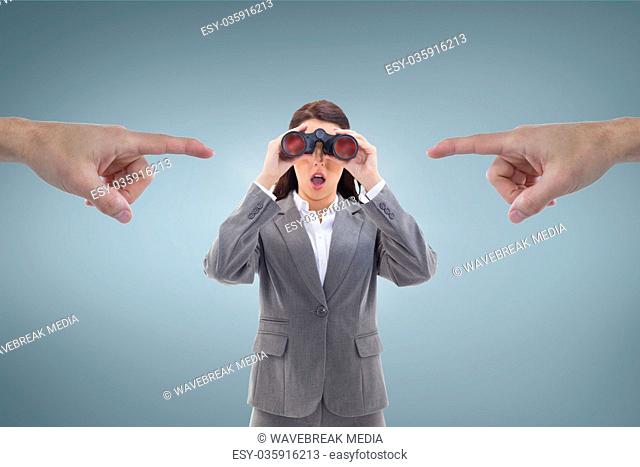Hands pointing at excited business woman looking through binoculars against blue background