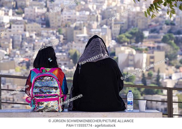 A Muslim woman sits with her little daughter on a bench on the Jebel al-Qalaa in Amman. Both enjoy the beautiful view of the old town