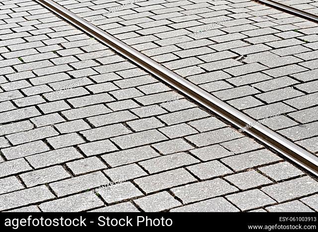 Detail on steel tram rail tiled stone floor around