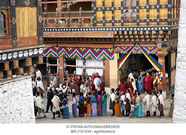 Tibetan Buddhist festival, people wearing the traditional Gho robe standing in a queue, Rinpung Dzong Monastery and Fortress, courtyard, Paro, Himalayas, Bhutan