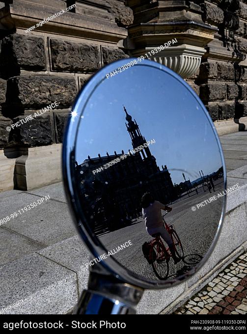 08 September 2023, Saxony, Dresden: The Hofkirche is reflected in the rearview mirror of a Vespa scooter parked in the sunshine on Theaterplatz
