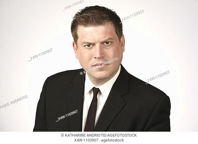 Serious midadult man wearing black suit and tie