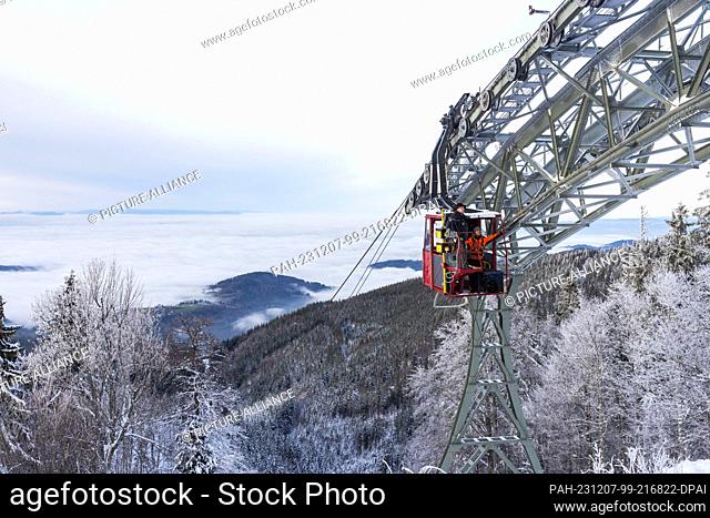 07 December 2023, Baden-Württemberg, Freiburg: Two employees of Freiburger Verkehrs AG (VAG) drive from the mountain station with a maintenance cabin to a...