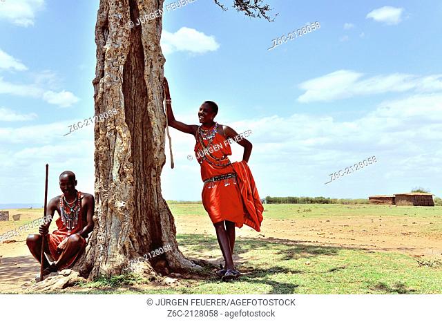 Massai in the shadow of an acacia tree, Masai Mara, Kenya