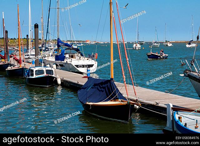 Boats moored at a jetty in Wells Town harbour Norfolk