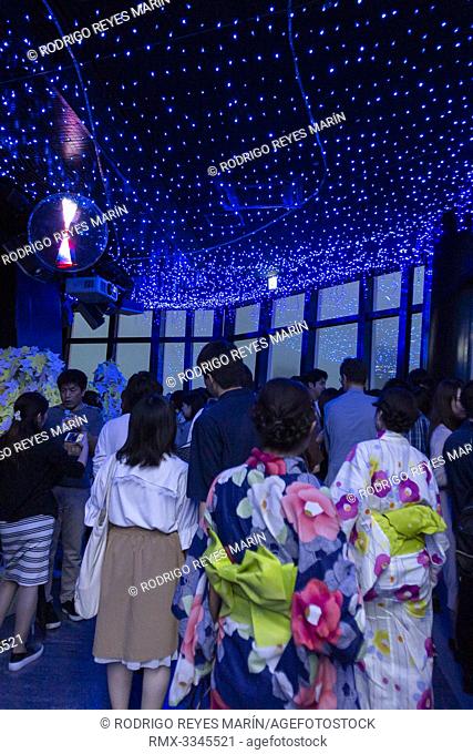 Visitors wearing traditional Japanese clothes (Yukata) contemplate the LED lights simulating the Milky Way in commemoration of Tanabata festival at Tokyo Tower...