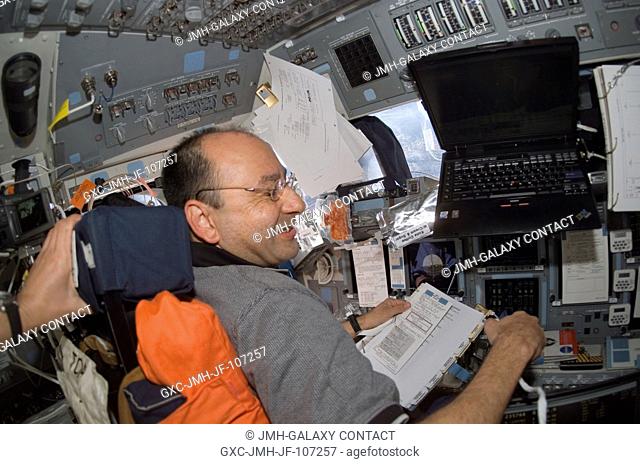 Astronaut Mark L. Polansky, STS-116 commander, occupies the commander's station on the flight deck of Space Shuttle Discovery during flight day three activities