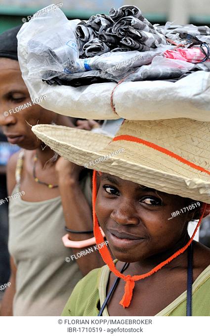 Young female vendor carrying goods on her head, urban market of Des Croix Bossales in the port district of La Saline, Port-au-Prince, Haiti, Caribbean