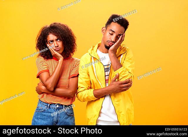 Girl feeling displeased and offended on boyfriend who fell asleep during date pursing lips frowning looking up while boyfriend leaning head on face with closed...