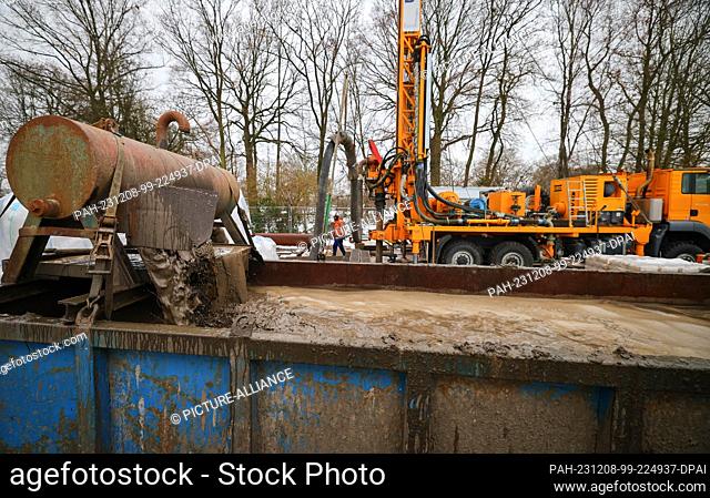 08 December 2023, Hamburg: A worker stands at a drilling rig on a construction site for a new drinking water well next to the Beentkamp retention basin