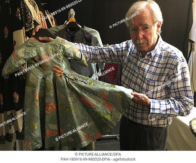 15 August 2018, Switzerland, Beckenried: Costume collector Martin Kamer showing a child's dressing gown from around 1710 He and his colleague W