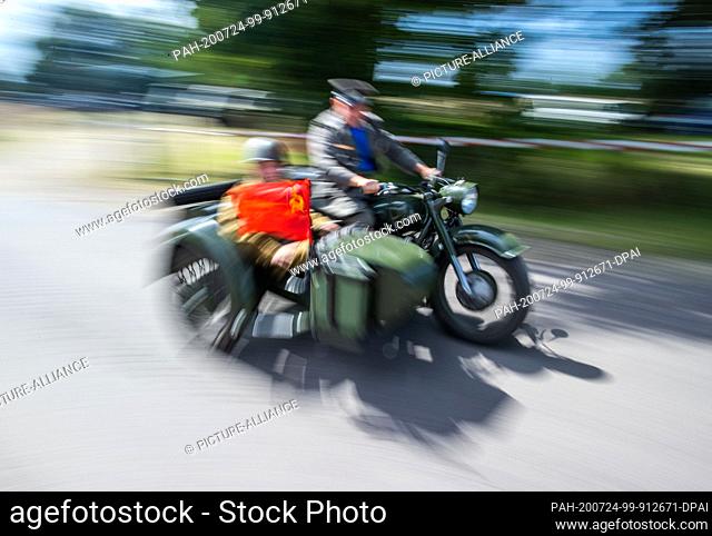 24 July 2020, Saxony-Anhalt, Beuster: Collectors drive a motorcycle team of the Soviet Red Army across the exhibition grounds during the blue light days in the...