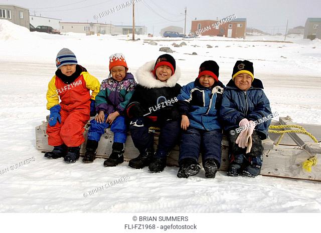 Kids sitting on Komatik/sled, Cambridge Bay, Nunavut