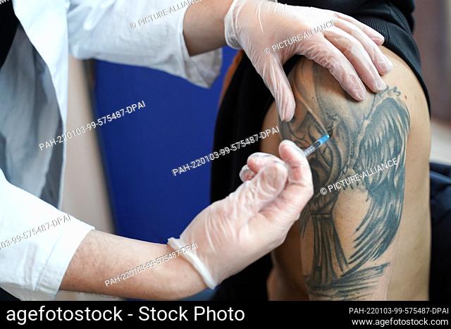 03 January 2022, Berlin: In the club ""Sage Beach"" a man receives a booster vaccination with the vaccine Moderna in his tattooed upper arm