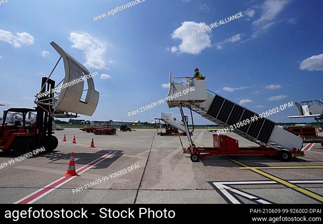 09 June 2021, Hamburg: Aircraft handler Erdogan Sati practices docking a passenger staircase onto an Airbus A320 on the apron
