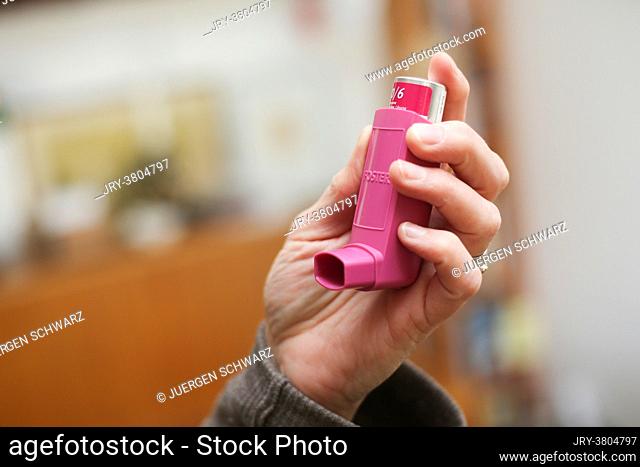 Germany, Bornheim, 12.04.2021: A woman picks up an asthma spray. A study shows that asthma sprays can alleviate the course of Covid-19 disease
