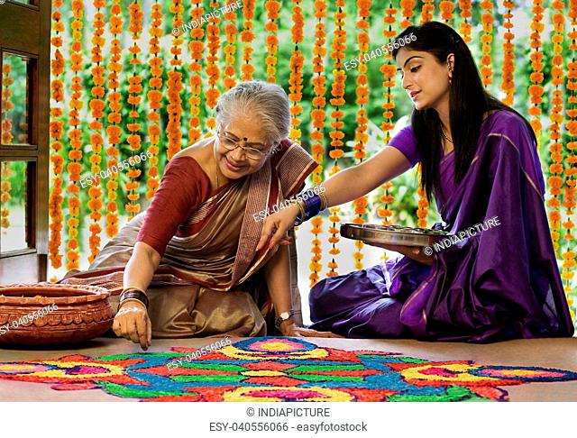 Mother and daughter making a rangoli